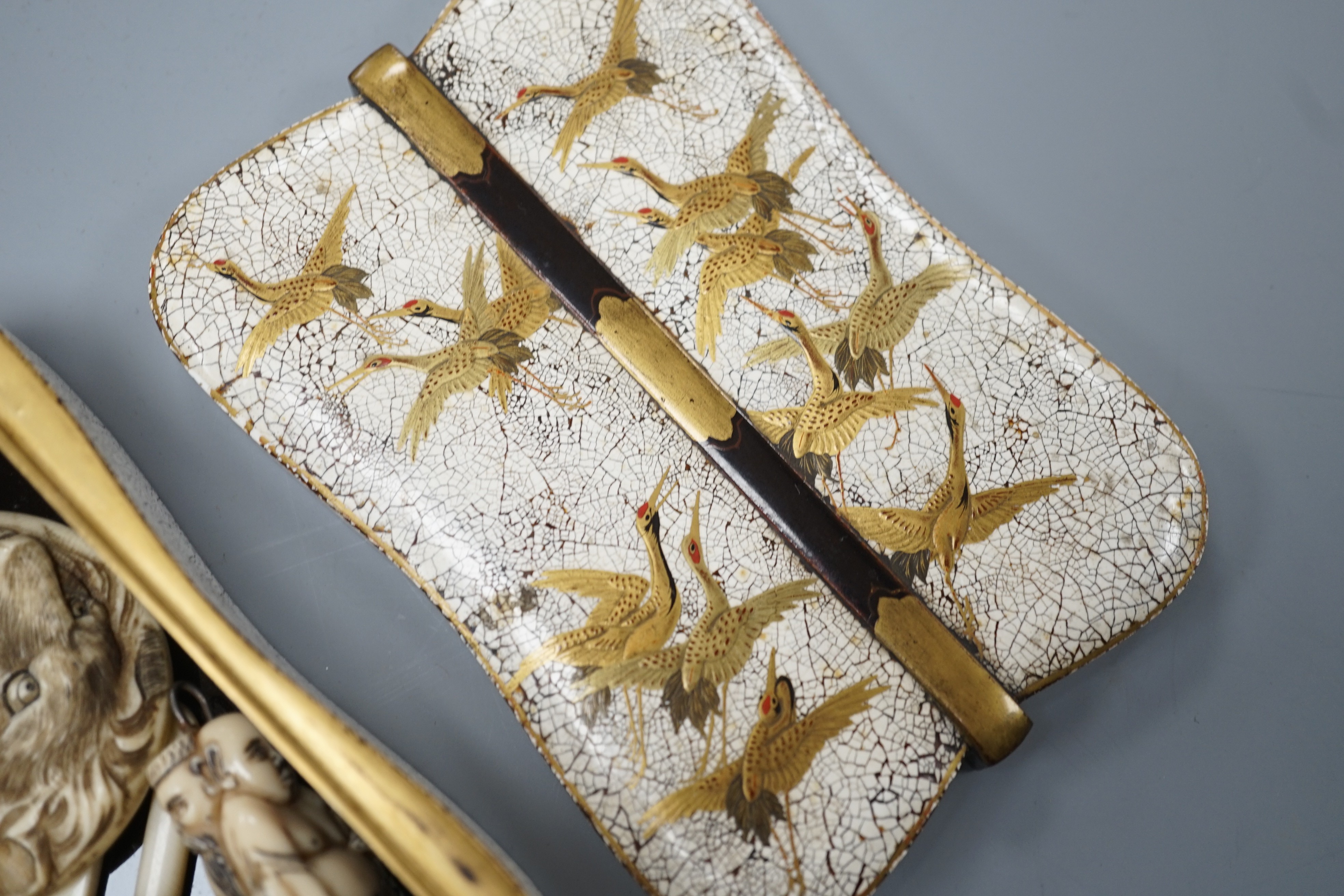 Two Japanese lacquer boxes, an ivory and bronze manju, an ivory ‘lion’ two-piece belt buckle and two simulated ivory items, late 19th/early 20th century, largest Box 11.5 cm
